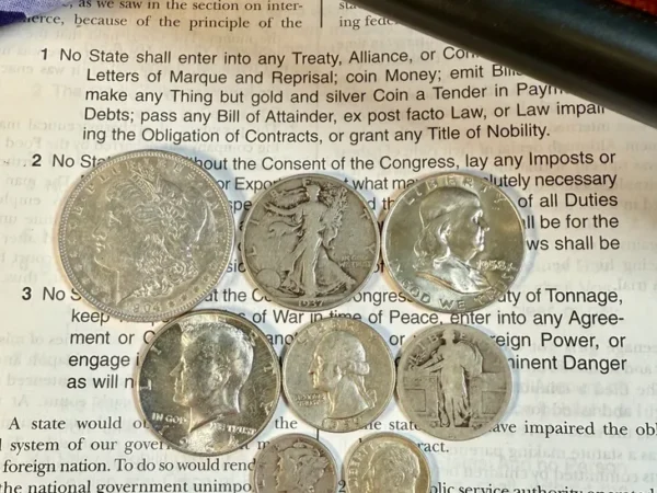 Nine silver coins on a document background.